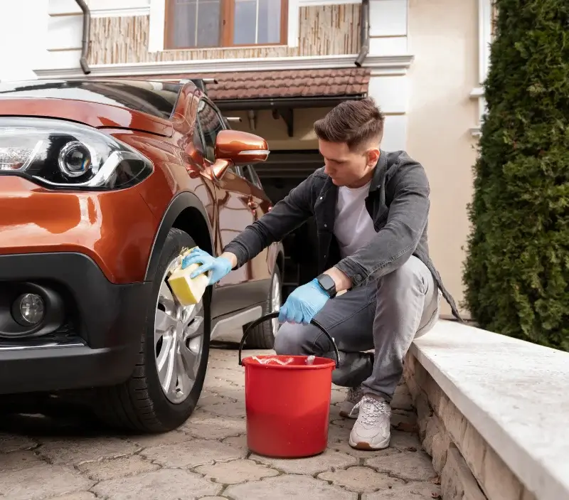 Lavage auto à domicile Val-d'Épy : professionnel intervenant sur un véhicule